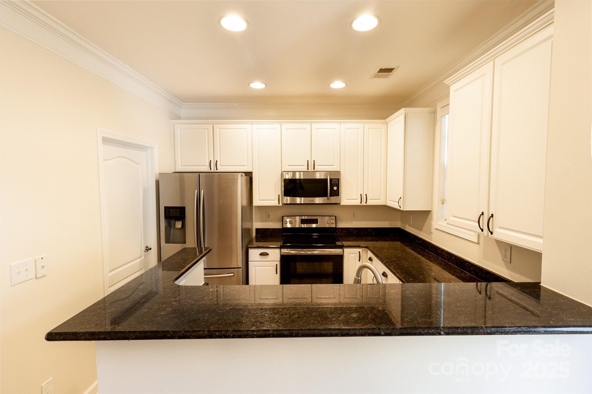 10419 Rocky Ford Club Road Charlotte, NC 28078 - Photo 15 of 37 a kitchen with kitchen island a sink stove and refrigerator