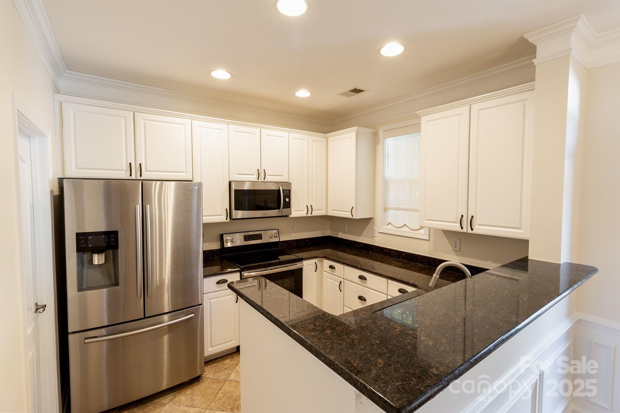 10419 Rocky Ford Club Road Charlotte, NC 28078 - Photo 16 of 37 a kitchen that has a refrigerator a stove white cabinets and a sink