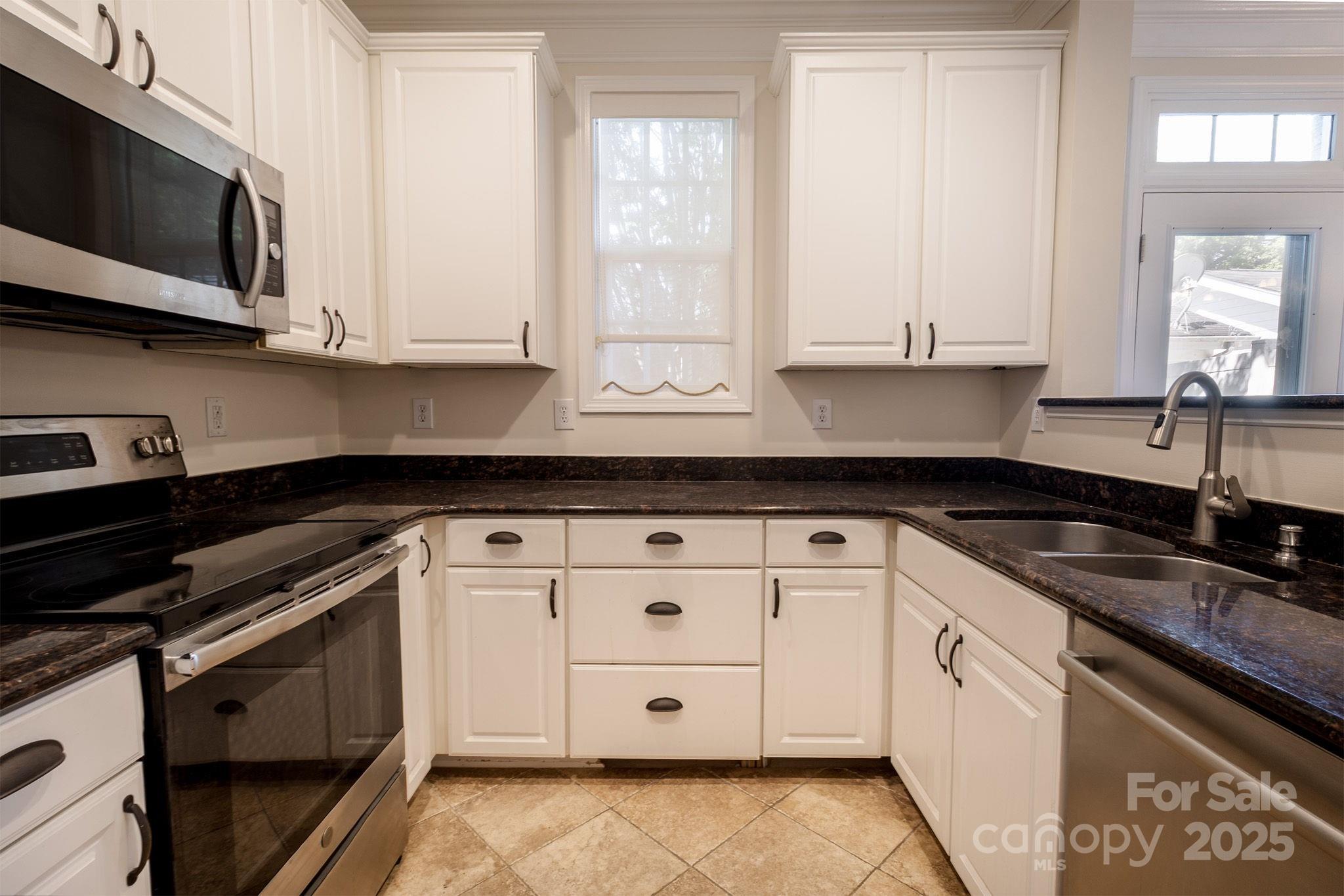 10419 Rocky Ford Club Road Charlotte, NC 28078 - Photo 17 of 37 a kitchen with stainless steel appliances granite countertop white cabinets sink and window