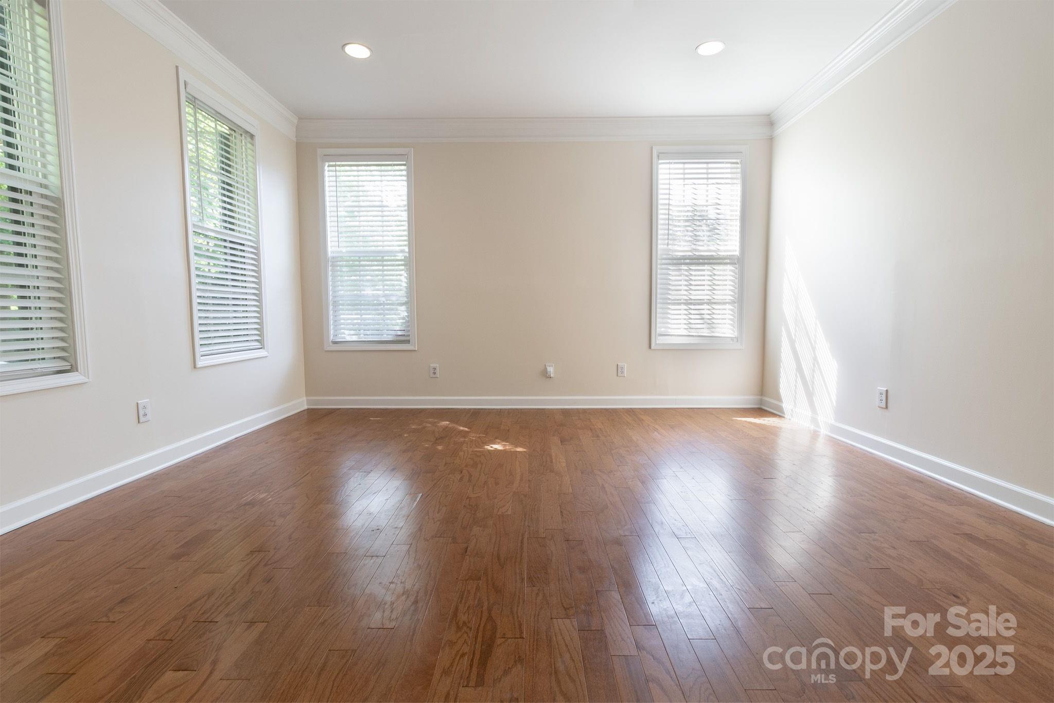 10419 Rocky Ford Club Road Charlotte, NC 28078 - Photo 5 of 37 an empty room with wooden floor and windows with curtains view