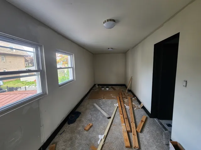 a view of a livingroom with wooden floor and a floor to ceiling window