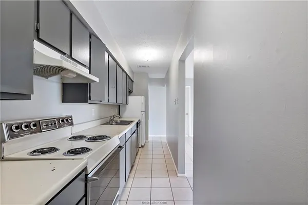 a kitchen with a sink and a stove top oven