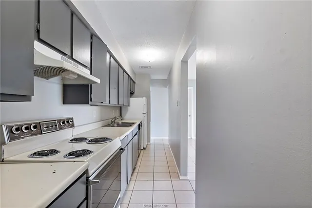 a kitchen with a sink and a stove top oven