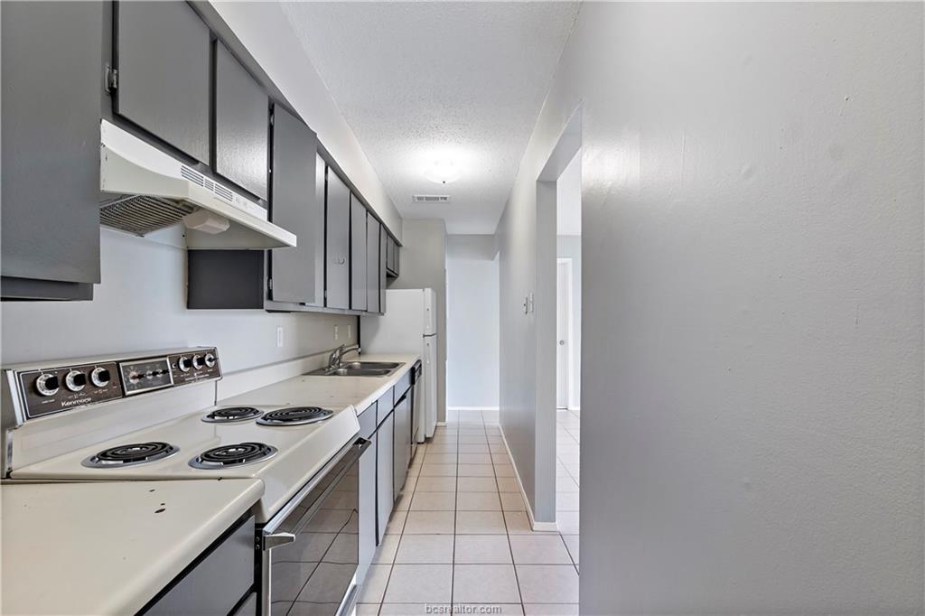 1112 Autumn Circle, Unit B College Station, TX 77840 - Photo 9 of 15 a kitchen with a sink and a stove top oven