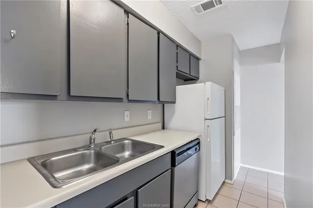 a kitchen with stainless steel appliances granite countertop a sink a refrigerator and a sink