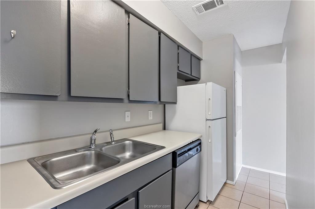 1112 Autumn Circle, Unit B College Station, TX 77840 - Photo 10 of 15 a kitchen with stainless steel appliances granite countertop a sink a refrigerator and a sink