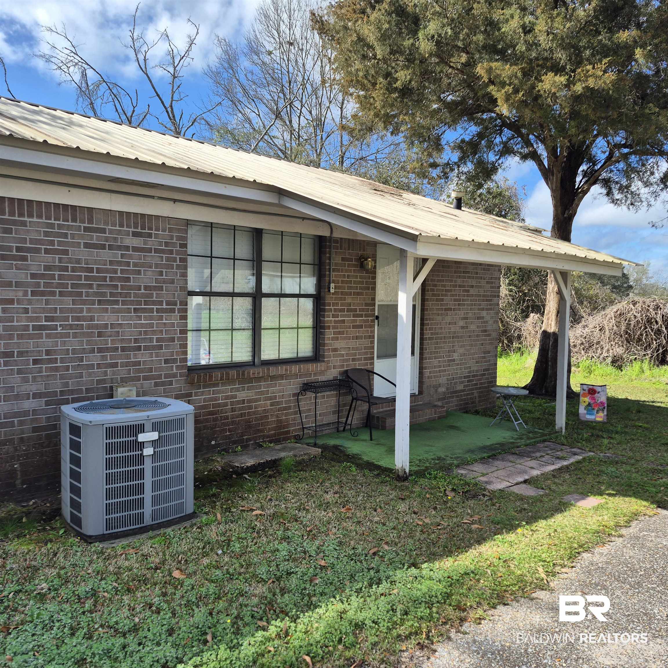 721 Perryman Street Evergreen, AL 36401 - Photo 20 of 26 View of front of property featuring brick siding, a front yard, and a metal roof