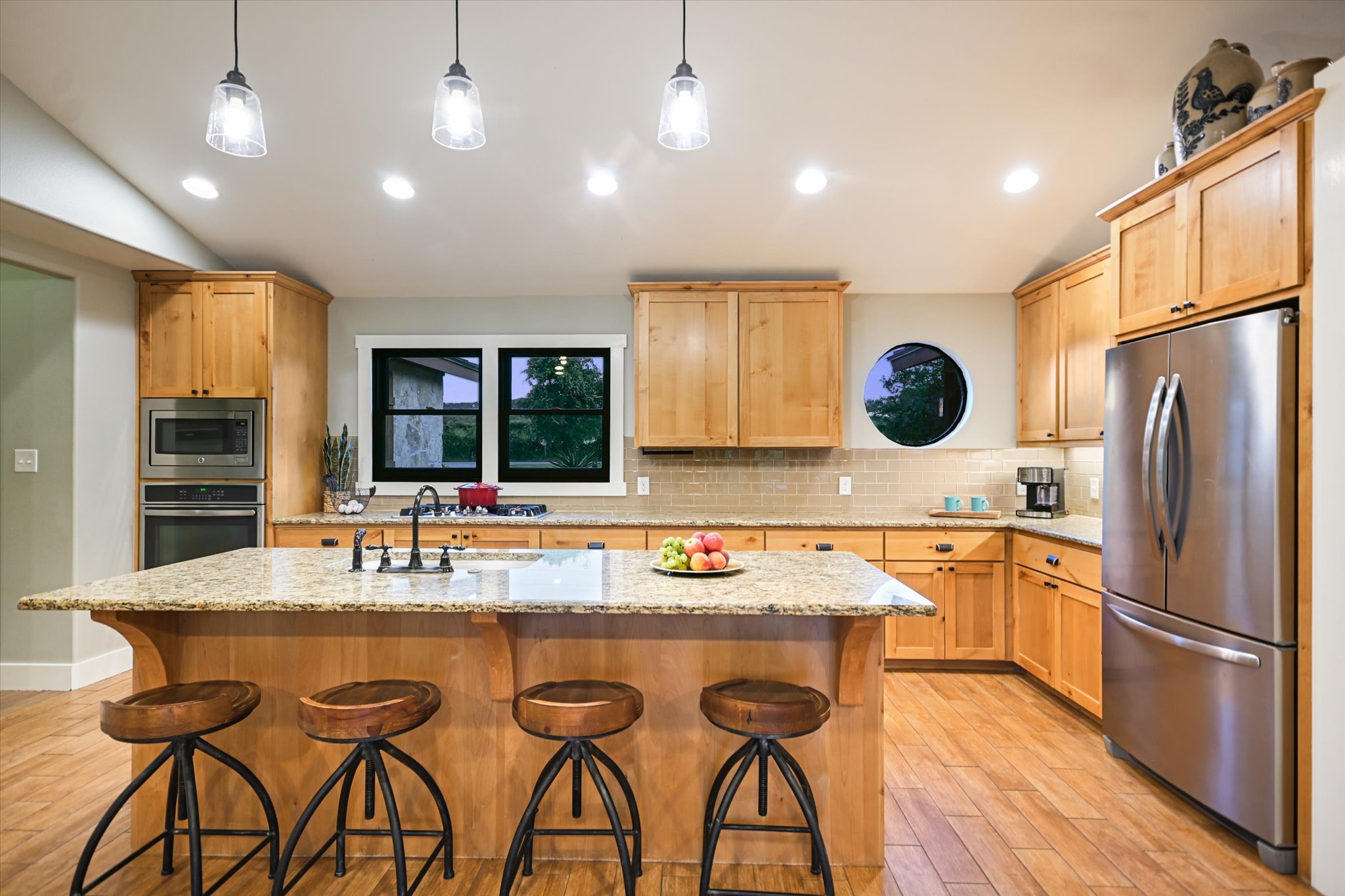 2411 Spoke Hollow Road Wimberley, TX 78676 - Photo 11 of 37 Culinary haven with granite counters, modern appliances, and a central island perfect for gathering.