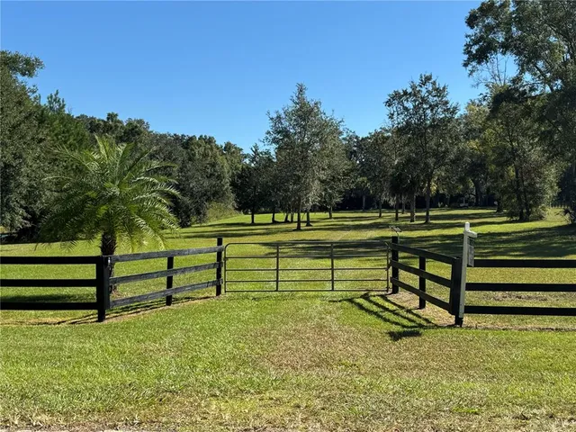 a view of a yard with wooden fence