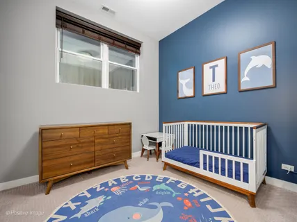 a bedroom with furniture and baby crib