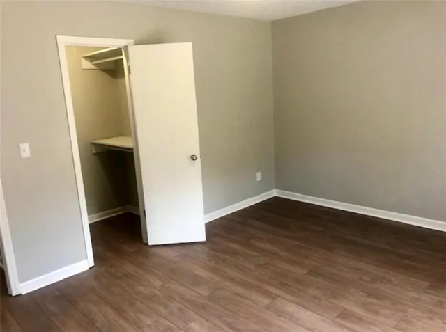 an empty room with wooden floor and closet