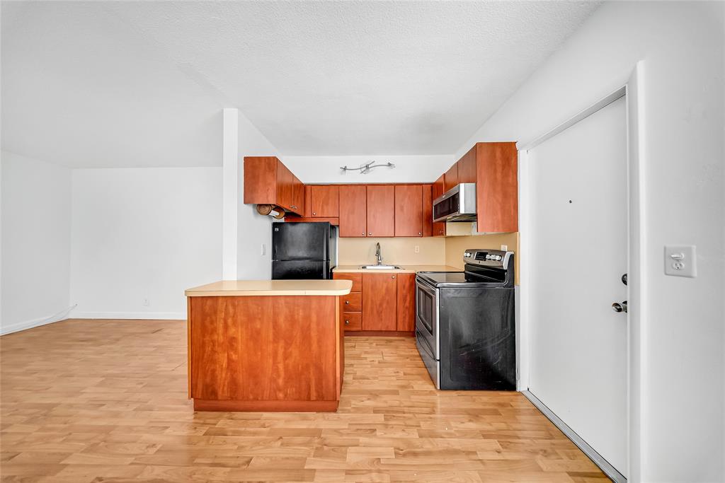 3525 Tyler Street, Unit 9 Hollywood, FL 33021 - Photo 4 of 24 a kitchen with stainless steel appliances granite countertop a refrigerator a stove top oven a sink and dishwasher
