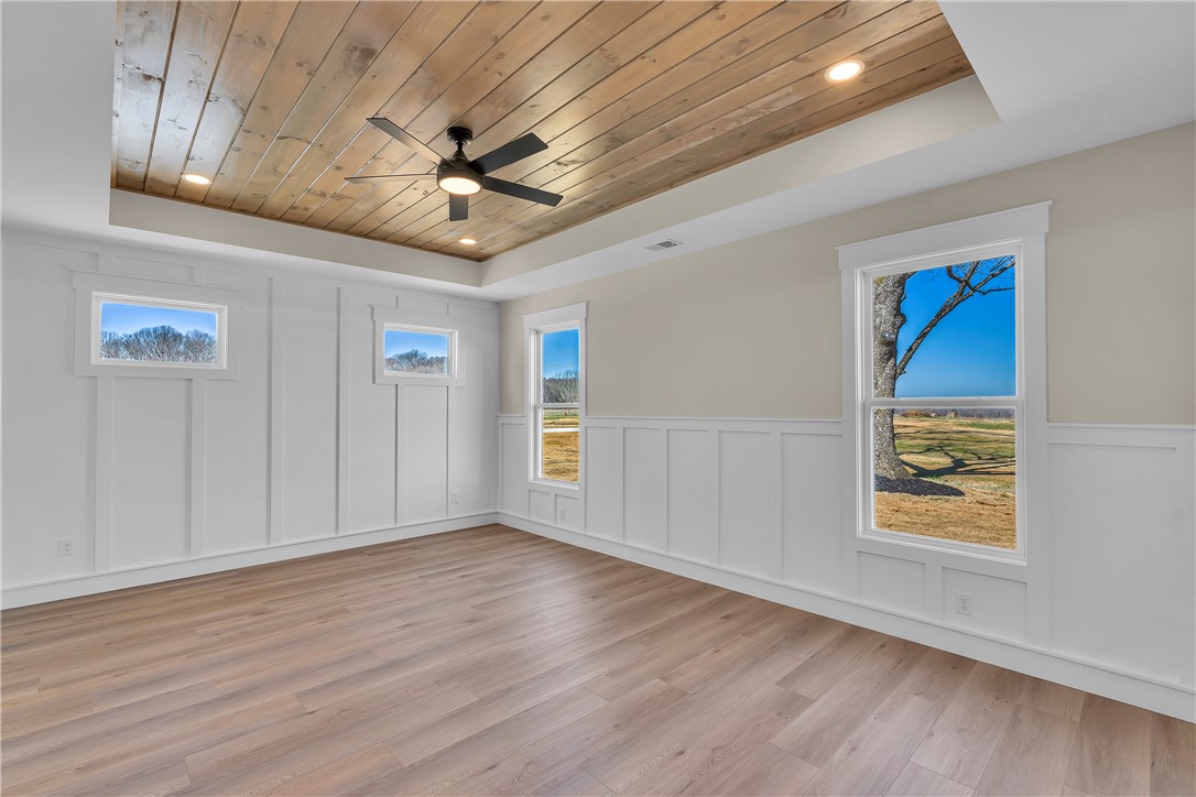 2816 Smith McGee Road Iva, SC 29655 - Photo 14 of 25 A striking tray ceiling with natural wood accents and a modern ceiling fan crowns this inviting space.