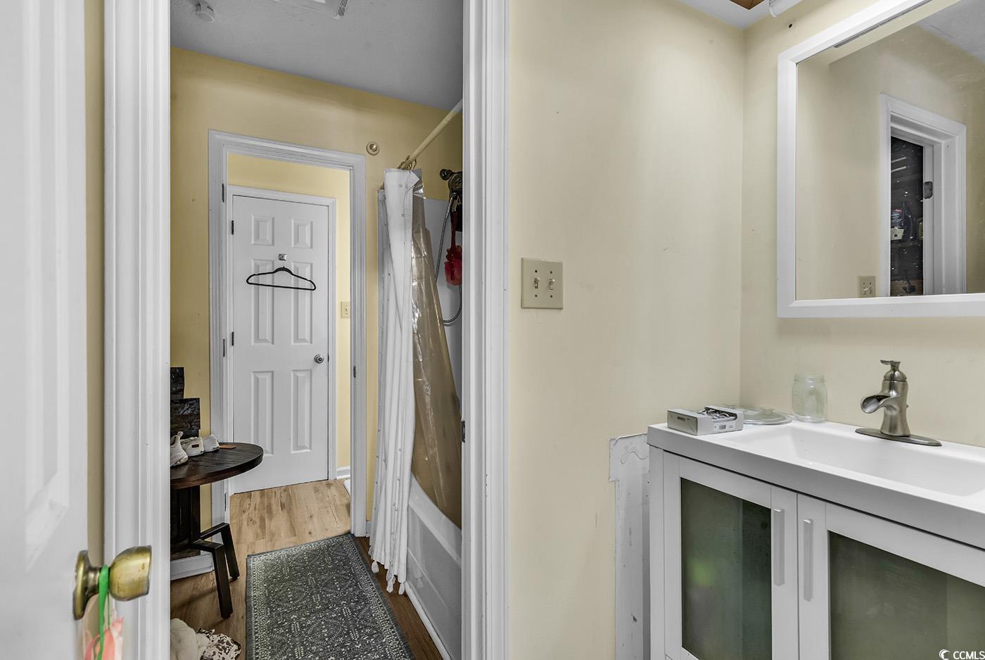 830 44th Avenue North, Unit I5 Myrtle Beach, SC 29577 - Photo 19 of 27 Bathroom featuring vanity, dark wood-style floors, and shower / bath combination with curtain