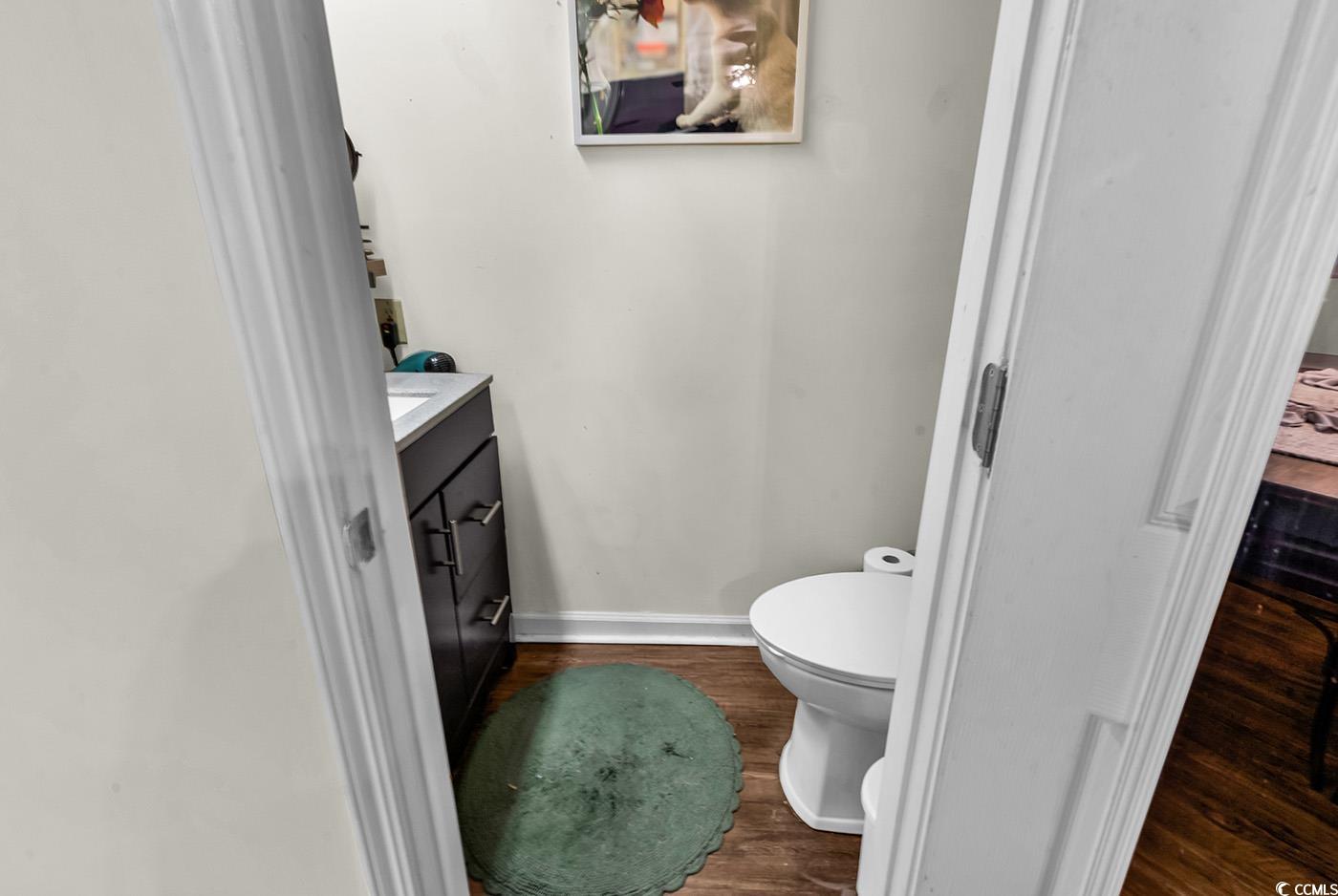 830 44th Avenue North, Unit I5 Myrtle Beach, SC 29577 - Photo 20 of 27 Half bathroom with dark wood-type flooring and vanity