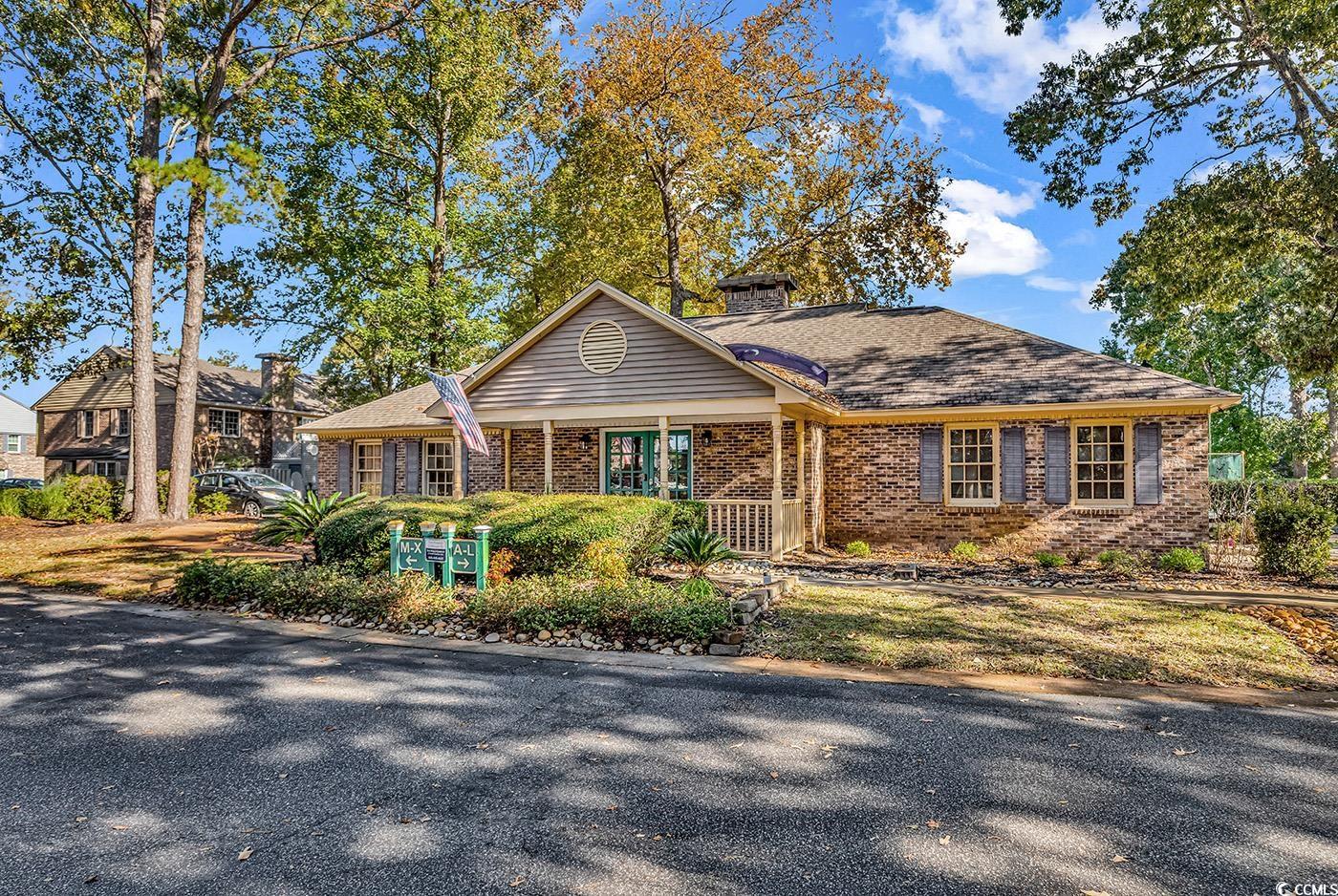 830 44th Avenue North, Unit I5 Myrtle Beach, SC 29577 - Photo 24 of 27 View of front of house with covered porch, brick siding, a chimney, and roof with shingles