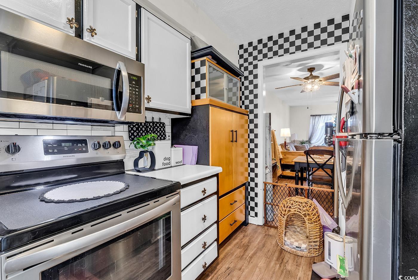 830 44th Avenue North, Unit I5 Myrtle Beach, SC 29577 - Photo 5 of 27 Kitchen with stainless steel appliances, light wood-style flooring, white cabinets, light countertops, and ceiling fan