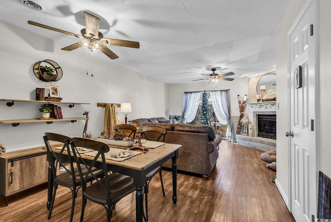 830 44th Avenue North, Unit I5 Myrtle Beach, SC 29577 - Photo 7 of 27 Dining room with a fireplace, dark wood finished floors, and a ceiling fan