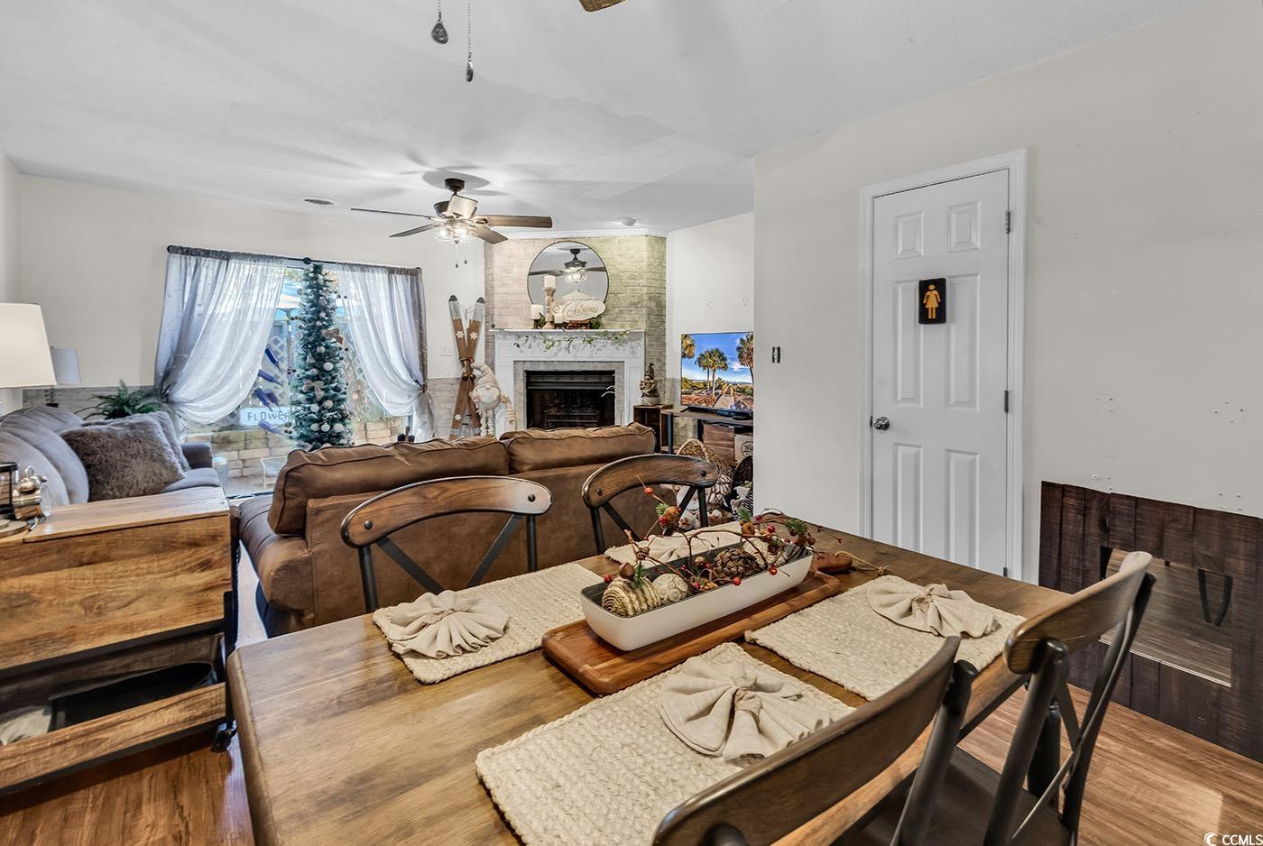 830 44th Avenue North, Unit I5 Myrtle Beach, SC 29577 - Photo 8 of 27 Dining space with wood finished floors, a fireplace, and ceiling fan