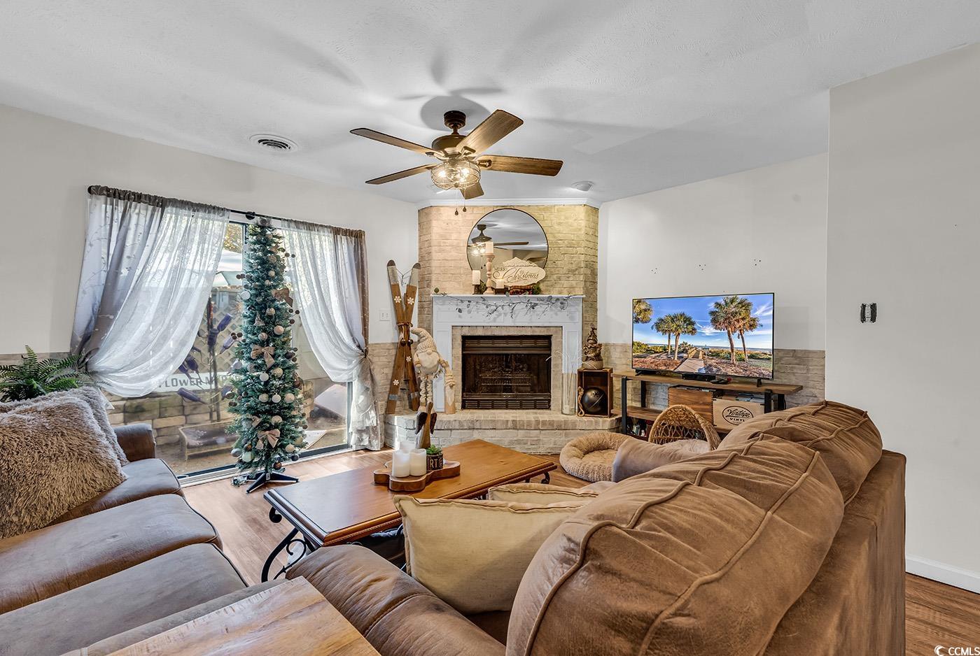 830 44th Avenue North, Unit I5 Myrtle Beach, SC 29577 - Photo 9 of 27 Living room with a brick fireplace, wood finished floors, and a ceiling fan
