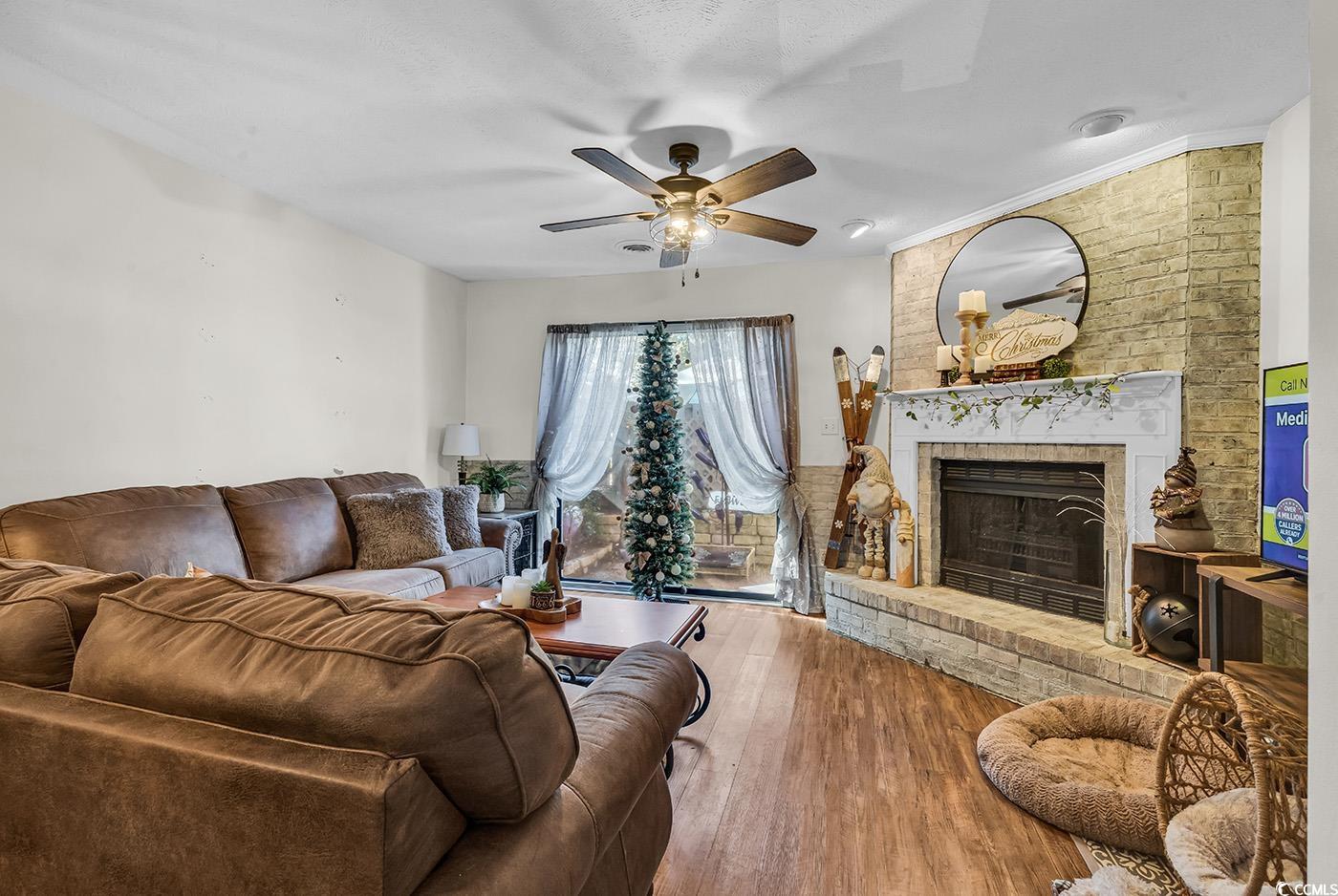 830 44th Avenue North, Unit I5 Myrtle Beach, SC 29577 - Photo 10 of 27 Living area with a brick fireplace, wood finished floors, and ceiling fan
