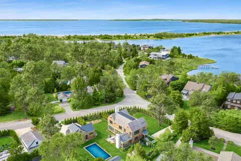 an aerial view of ocean and residential houses with outdoor space