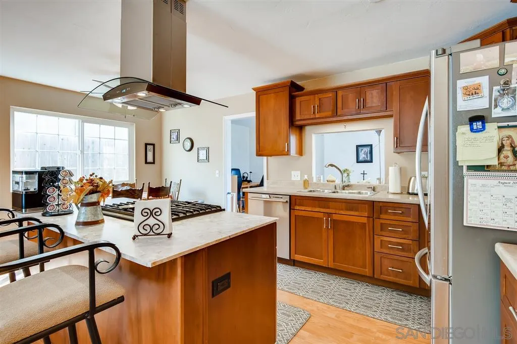 9809 Medina Drive Santee, CA 92071 - Photo 6 of 22 a very nice looking kitchen with granite countertop a stove cabinets and chairs