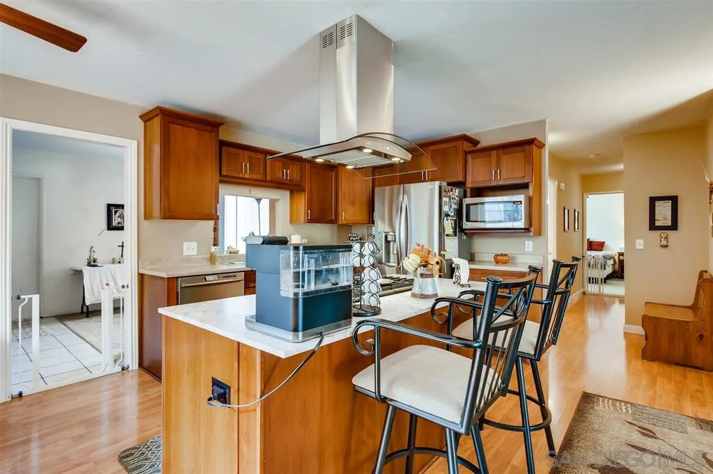 9809 Medina Drive Santee, CA 92071 - Photo 7 of 22 a kitchen with stainless steel appliances granite countertop a stove top oven a sink a dining table and chairs