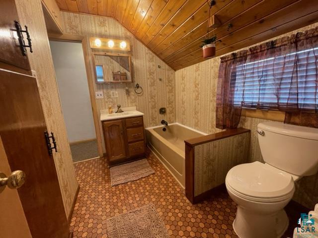 32 West Shagawa Road Ely, MN 55731 - Photo 16 of 26 Bathroom featuring wooden ceiling, toilet, tile patterned floors, vanity, and vaulted ceiling