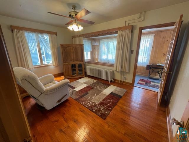 32 West Shagawa Road Ely, MN 55731 - Photo 6 of 26 Living room with ceiling fan, hardwood / wood-style flooring, radiator heating unit, and a wealth of natural light