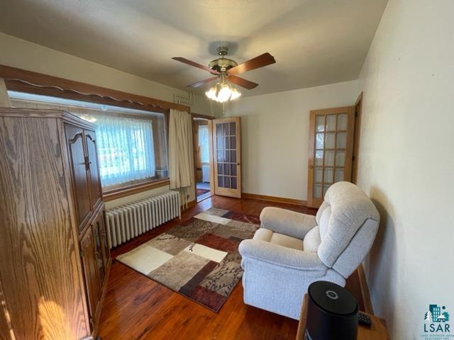 32 West Shagawa Road Ely, MN 55731 - Photo 7 of 26 Living room with ceiling fan, radiator, and dark wood-type flooring