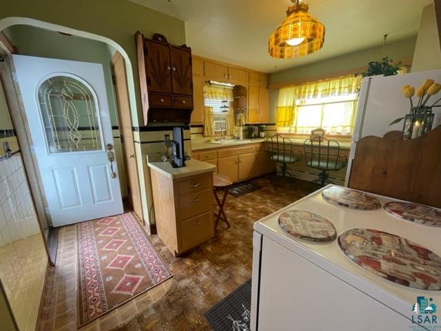 32 West Shagawa Road Ely, MN 55731 - Photo 9 of 26 Kitchen with white refrigerator, sink, and decorative light fixtures