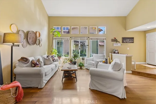 a living room with furniture kitchen view and a large window