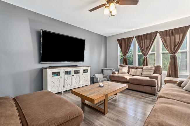 2602 Lundquist Drive Aurora, IL 60503 - Photo 5 of 30 a living room with furniture a flat screen tv and a floor to ceiling window
