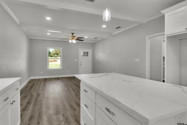 a view of an empty room and window and wooden floor