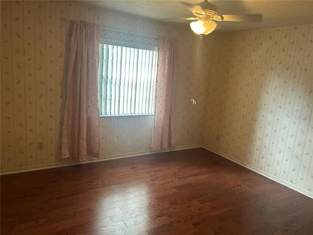 an empty room with wooden floor and windows in it