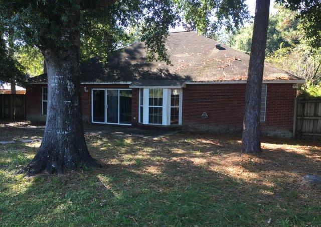 4587 Top Flight Drive Crestview, FL 32539 - Photo 12 of 16 a backyard of a house with yard table and large tree