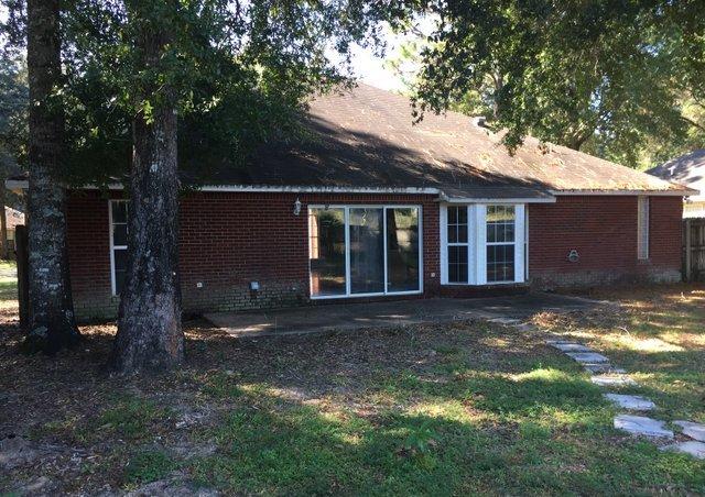4587 Top Flight Drive Crestview, FL 32539 - Photo 13 of 16 a view of a brick house next to a yard with large trees