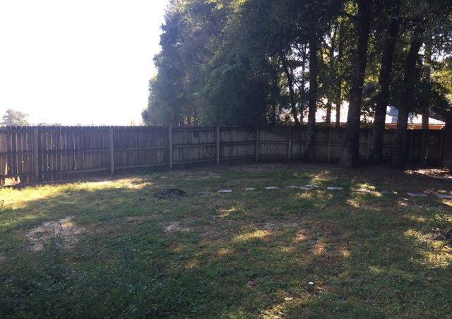 4587 Top Flight Drive Crestview, FL 32539 - Photo 14 of 16 a view of a backyard with a large tree and wooden fence
