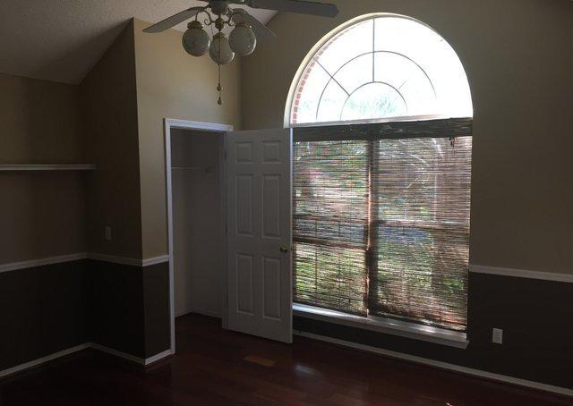 4587 Top Flight Drive Crestview, FL 32539 - Photo 8 of 16 an empty room with wooden floor a fan and a window