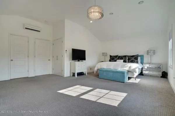 a spacious bedroom with a bed and a view of bathroom