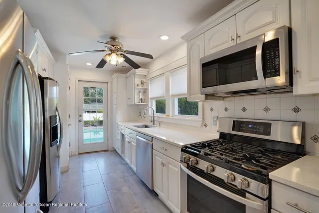 a kitchen with stainless steel appliances a stove a microwave a sink and cabinets