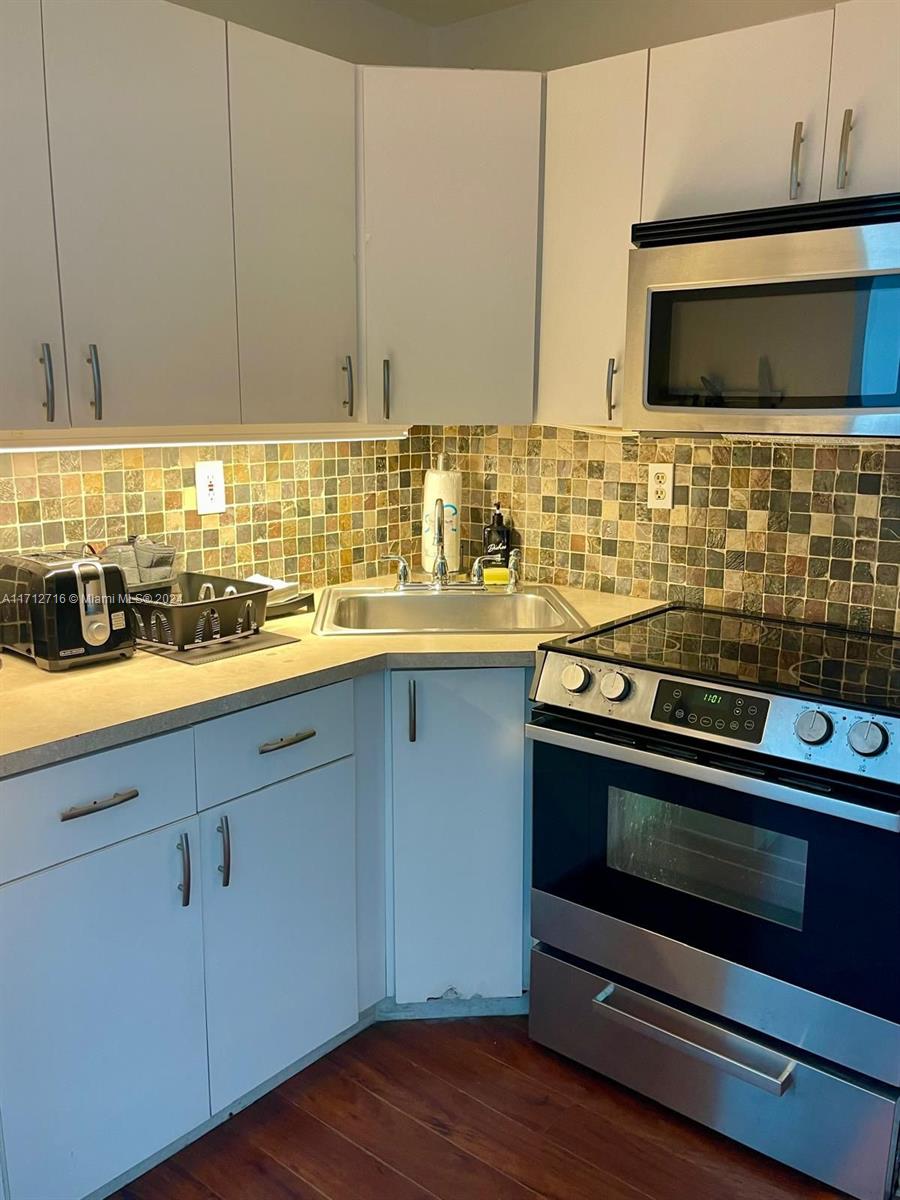5445 Collins Avenue, Unit TS7 Miami Beach, FL 33140 - Photo 13 of 24 a kitchen with a stove and a microwave