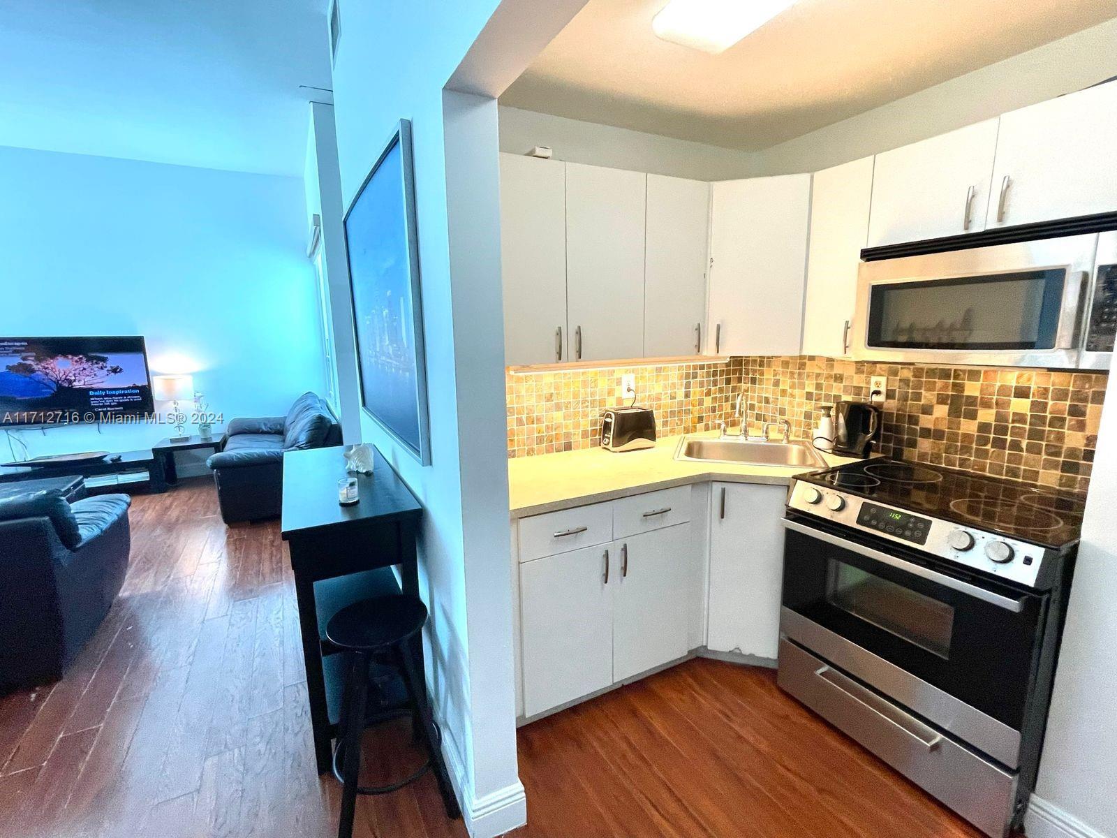 5445 Collins Avenue, Unit TS7 Miami Beach, FL 33140 - Photo 14 of 24 a kitchen with wooden floors and appliances