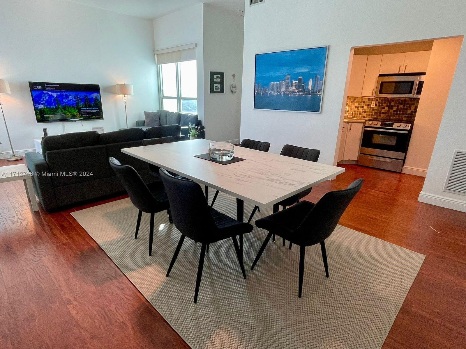 5445 Collins Avenue, Unit TS7 Miami Beach, FL 33140 - Photo 3 of 24 a view of a dining room with furniture and wooden floor