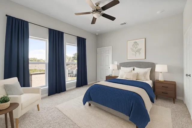 a spacious bedroom with a bed and glass window