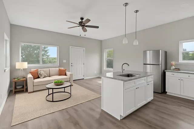 a living room with furniture a ceiling fan and white walls