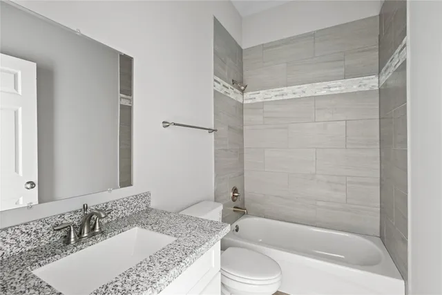 a bathroom with a granite countertop tub sink and mirror