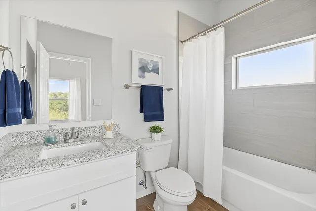 a bathroom with a granite countertop toilet a sink and a bathtub