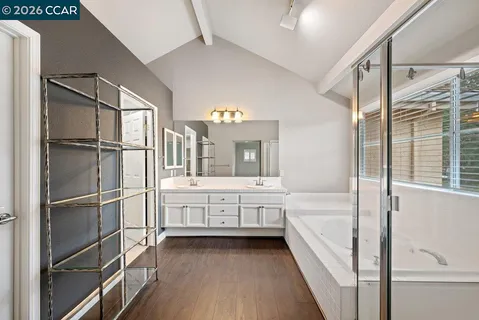 a bathroom with a granite countertop sink and a bathtub